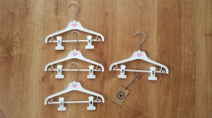 Wieszaki niemowlęce z poprzeczką. Biało-różowe wieszaki z klipsami. Wieszaki do niemowlęcej garderoby.