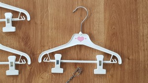 Wieszaki niemowlęce z poprzeczką. Biało-różowe wieszaki z klipsami. Wieszaki do niemowlęcej garderoby.