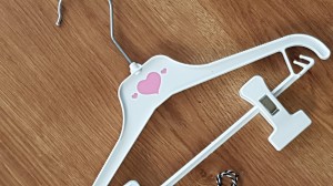 Wieszaki niemowlęce z poprzeczką. Biało-różowe wieszaki z klipsami. Wieszaki do niemowlęcej garderoby.