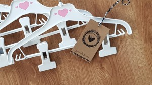 Wieszaki niemowlęce z poprzeczką. Biało-różowe wieszaki z klipsami. Wieszaki do niemowlęcej garderoby.