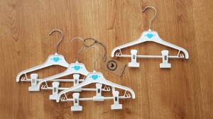 Wieszaki niemowlęce z poprzeczką. Biało-niebieskie wieszaki z klipsami. Wieszaki do niemowlęcej garderoby.