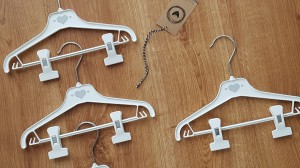 Wieszaki niemowlęce z poprzeczką. Biało-szare wieszaki z klipsami. Wieszaki do niemowlęcej garderoby.