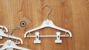 Wieszaki niemowlęce z poprzeczką. Biało-szare wieszaki z klipsami. Wieszaki do niemowlęcej garderoby.