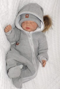 Oryginalny kombinezon wiosenno-jesienny dla niemowlaka, noworodka. Włóczkowy kombinezon dla niemowląt. Ciepły kombinezon z kapturem i pomponem futerkowym. Unikalny szary kombinezon na wyjście ze szpitala, na chrzest. Must have wyprawki dla noworodka.