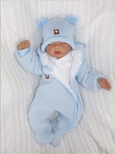 Oryginalny kombinezon wiosenno-jesienny dla niemowlaka, noworodka. Włóczkowy kombinezon dla niemowląt. Ciepły kombinezon z kapturem i pomponem futerkowym. Unikalny niebieski kombinezon na wyjście ze szpitala, na chrzest. Must have wyprawki dla noworodka.