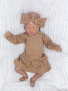 Bodosukienka z długim rękawem dla dziewczynki. Bodosukienka w jednolitym kolorze. Bawełniana bodosukienka w beżowym kolorze.