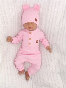 Prążkowany zestaw dla niemowlaka. Komplet całoroczny w  kolorze różowym. Prążkowane spodnie w komplecie z body i czapką dla niemowlaka.