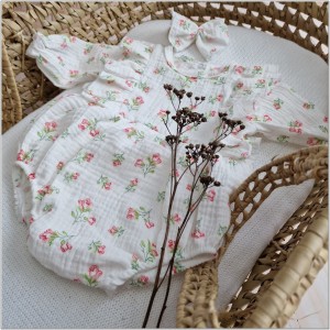 Muślinowe body niemowlęca z falbankami. Przewiewna dziewczęce body z długim rękawem. Body z opaską dla niemowlaka. Białe body muślinowe w różyczki dla małej dziewczynki.