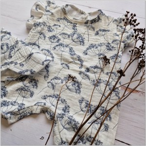 Muślinowy kombinezon niemowlęca. Przewiewny dziewczęcy rampers. Kombinezon na lato z czapeczką dla niemowlaka. Biały rampers muślinowy w kwiaty dla małej dziewczynki.