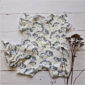 Muślinowy kombinezon niemowlęca. Przewiewny dziewczęcy rampers. Kombinezon na lato z czapeczką dla niemowlaka. Biały rampers muślinowy w kwiaty dla małej dziewczynki.