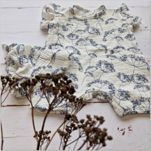 Muślinowy kombinezon niemowlęca. Przewiewny dziewczęcy rampers. Kombinezon na lato z czapeczką dla niemowlaka. Biały rampers muślinowy w kwiaty dla małej dziewczynki.