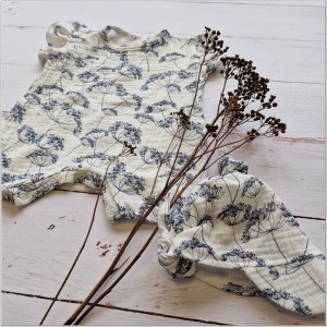 Muślinowy kombinezon niemowlęca. Przewiewny dziewczęcy rampers. Kombinezon na lato z czapeczką dla niemowlaka. Biały rampers muślinowy w kwiaty dla małej dziewczynki.