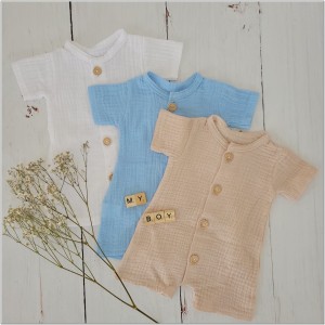 Muślinowy rampers niemowlęcy dla chłopca. Przewiewny chłopięcy rampers z drewnianymi guzikami.  Rampers muślinowy w kolorze  beżowym dla małego chłopczyka.