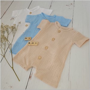 Muślinowy rampers niemowlęcy dla chłopca. Przewiewny chłopięcy rampers z drewnianymi guzikami.  Rampers muślinowy w kolorze  beżowym dla małego chłopczyka.