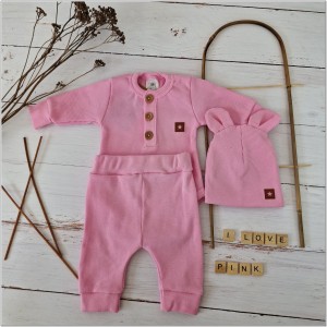 Prążkowany zestaw dla niemowlaka. Komplet całoroczny w  kolorze różowym. Prążkowane spodnie w komplecie z body i czapką dla niemowlaka.