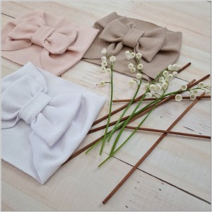 Szeroka opaska niemowlęca z kokardą. Opaska prążkowana dla dziewczynki. Opaska w kolorze białym dla dziewczynki.