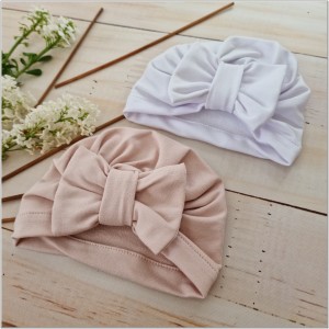 Cienka niemowlęca czapka prążkowana. Czapka z kokardą dla dziewczynki. Dresowa czapka z kokardą dla dziewczynki w kolorze białym.