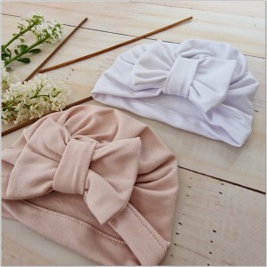 Cienka niemowlęca czapka prążkowana. Czapka z kokardą dla dziewczynki. Dresowa czapka z kokardą dla dziewczynki w kolorze białym.