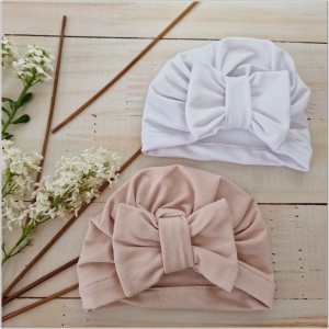 Cienka niemowlęca czapka prążkowana. Czapka z kokardą dla dziewczynki. Dresowa czapka z kokardą dla dziewczynki w kolorze białym.