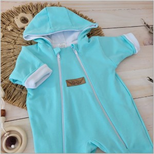 Kombinezon niemowlęcy dwuwarstwowy. Kombinezon dla noworodka zapinany na dwa zamki. Miętowo-biały kombinezon całoroczny dla niemowlaka. Must have wyprawki dla noworodka. Kombinezon niemowlęcy z kapturem.